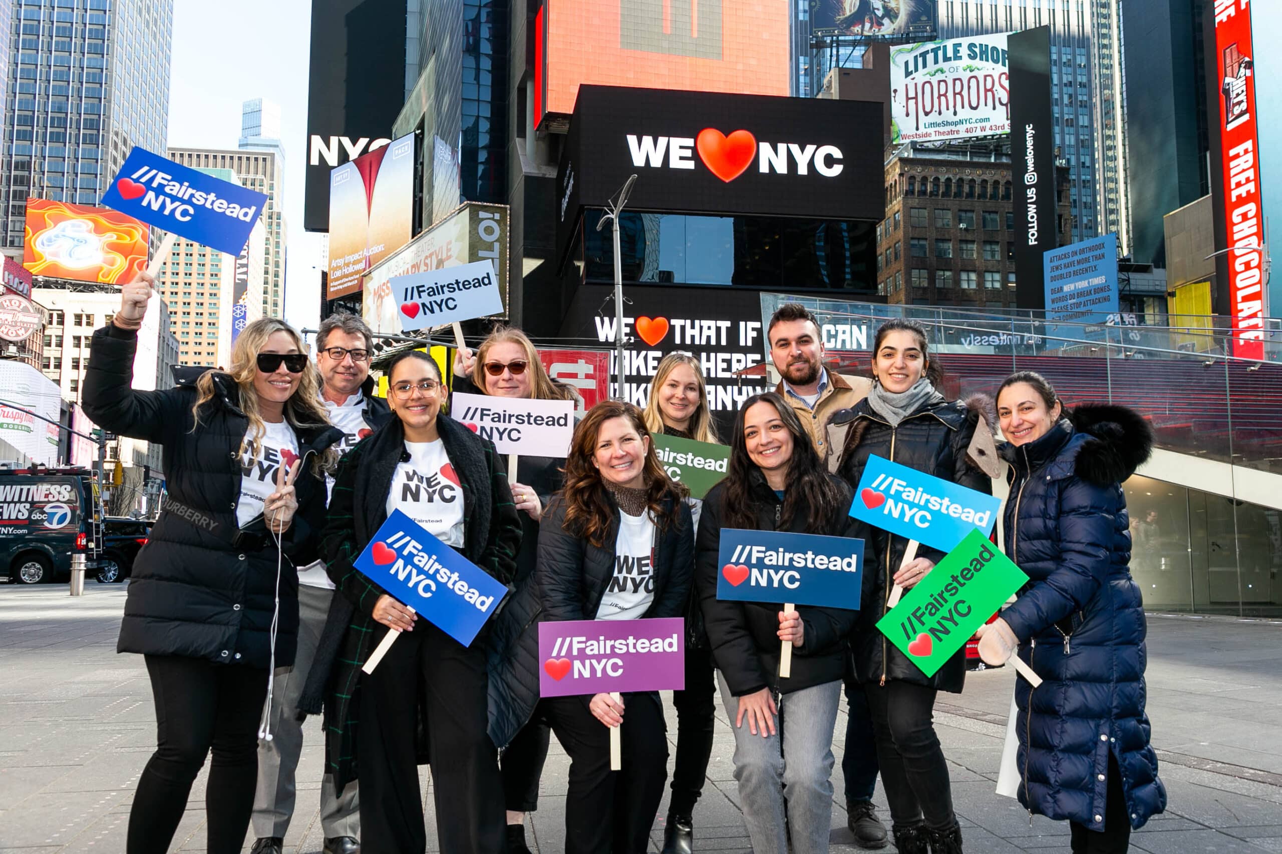 group of people in downtown new york with we love nyc signs